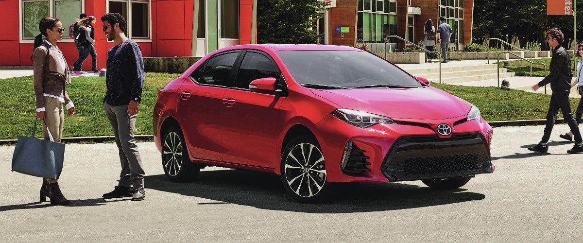 A red 2020 Toyota Corolla parked outside of a building