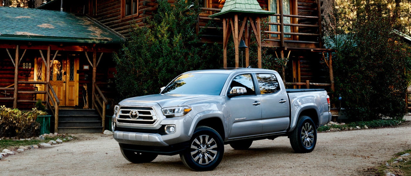 A silver 2020 Toyota Tacoma parked in front of a cabin