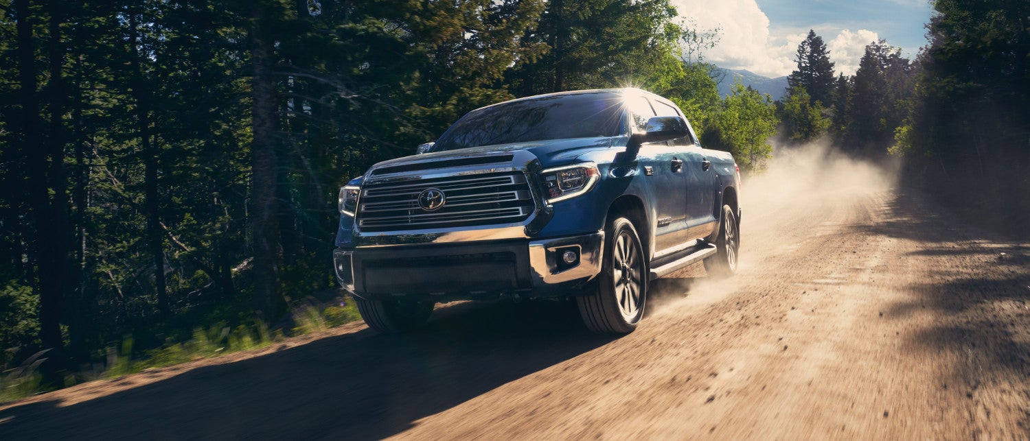 A blue 2020 Toyota Tundra driving down a dirt road