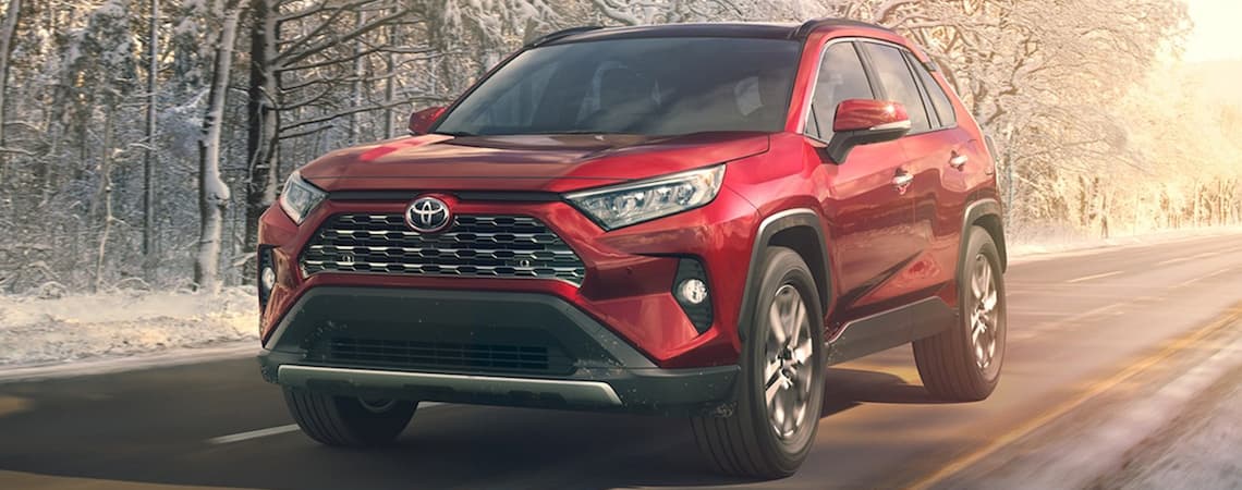 A red 2019 Toyota RAV4 driving in the winter