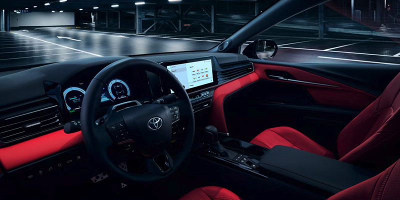 Interior view of a vehicle, showcasing the dashboard with illuminated Toyota dashboard lights.