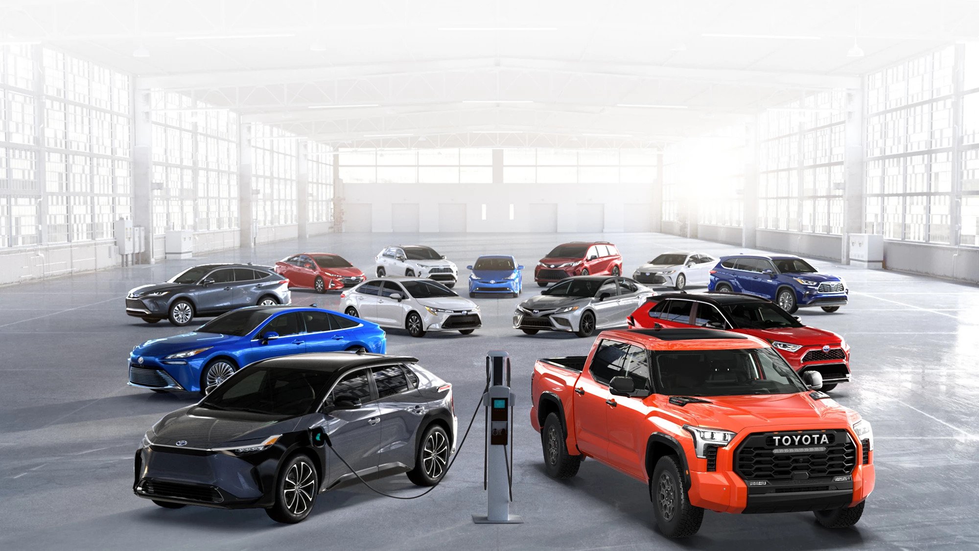 A spacious room filled with various cars and a charging station, highlighting Toyota's gas mileage models for 2026.