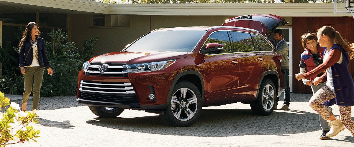 A red 2019 Toyota Highlander parked in a driveway