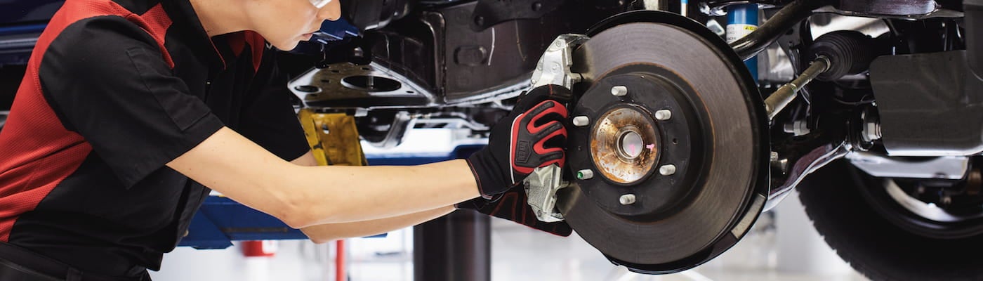 A service technician replacing brakes on a Toyota vehicle